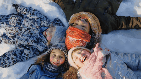 View from above as children lay in the snow. Text reads, "A Peaceful Season. Promoting empathy during this season of caring."